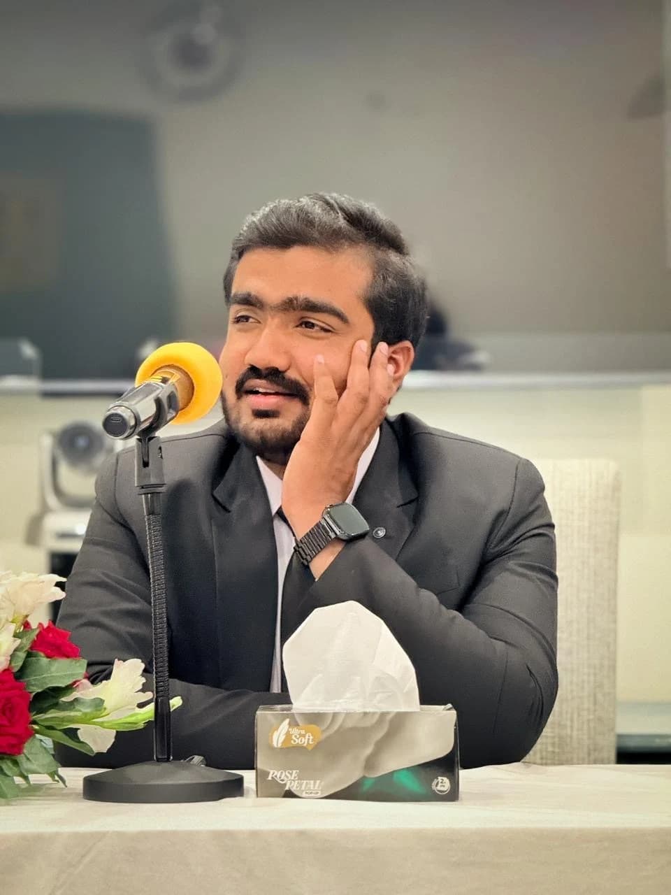 Faiz speaking into a microphone at a professional gathering