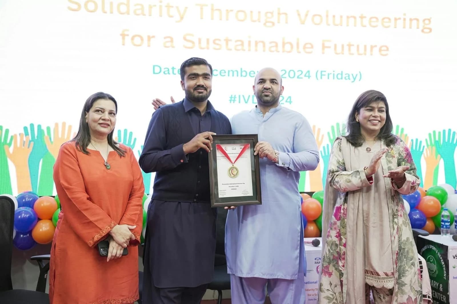 Faiz receiving recognition at International Volunteer Day 2024